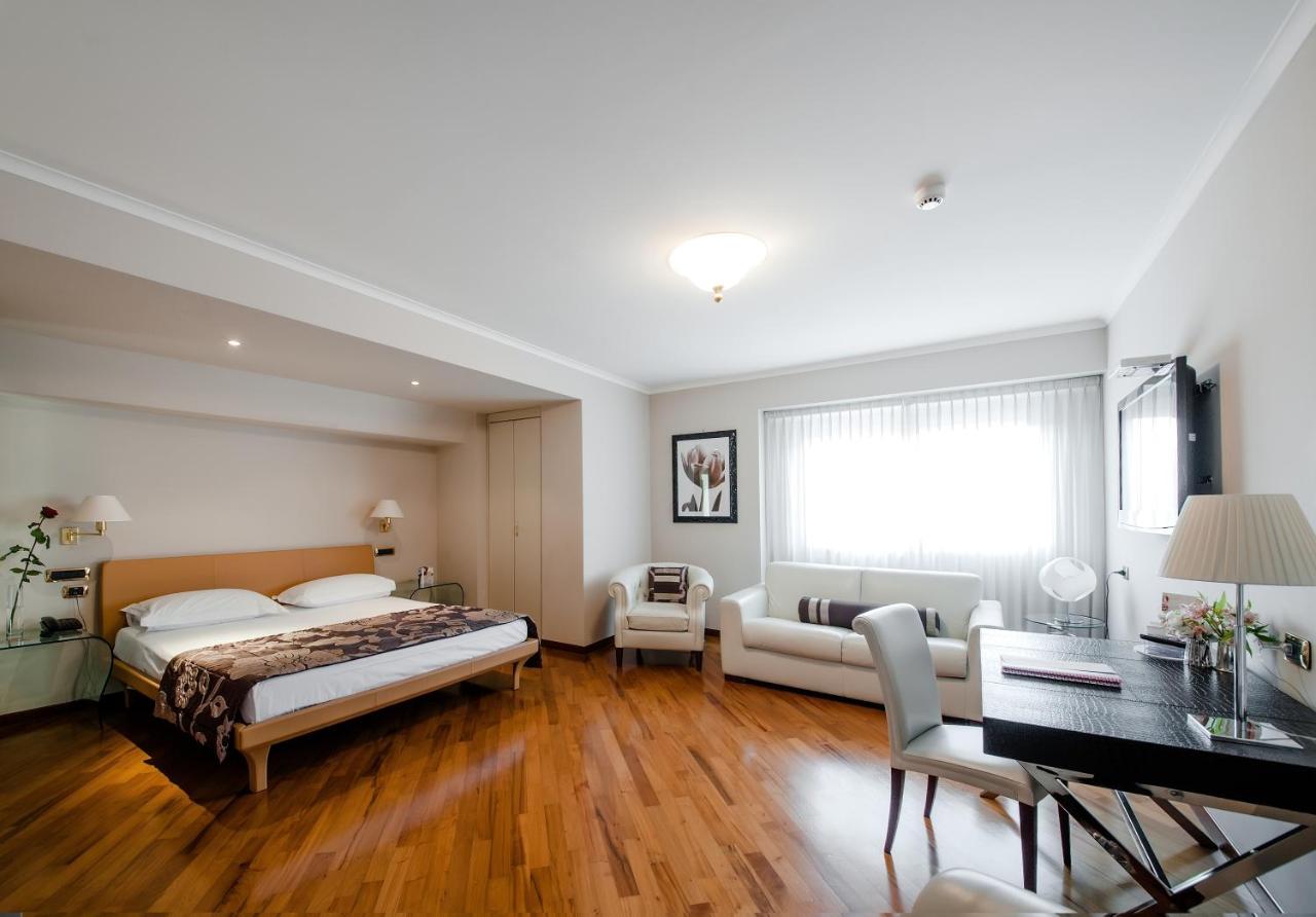 een slaapkamer met een bed, een bureau en een tafel bij Hotel Villa Traiano in Benevento