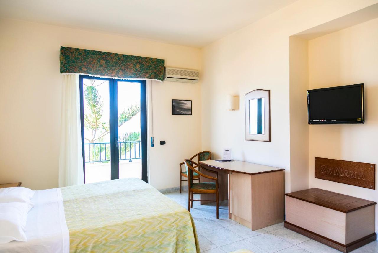 een hotelkamer met een bed, een bureau en een televisie bij Hotel Za Maria in Santo Stefano di Camastra