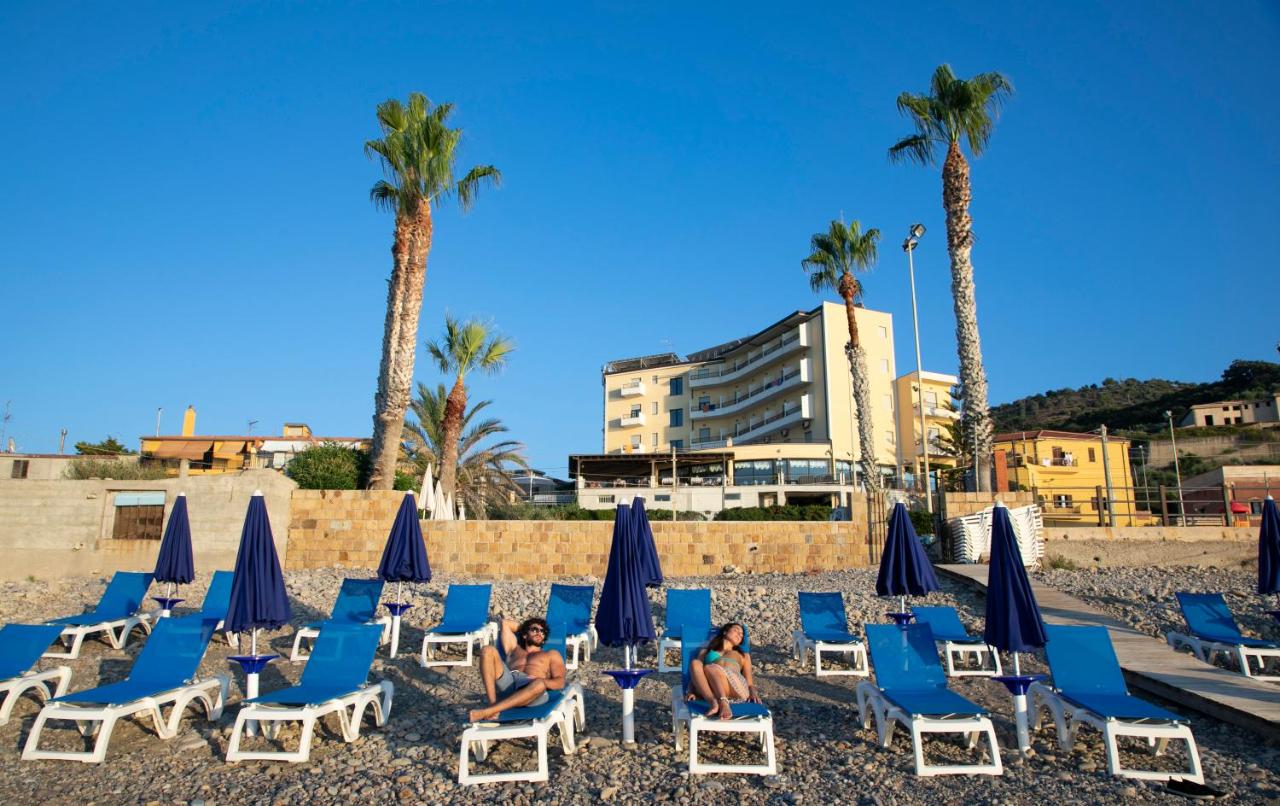 een groep mensen die op stoelen op het strand zitten bij Hotel Za Maria in Santo Stefano di Camastra