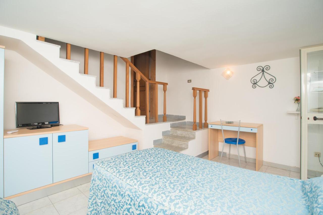 een slaapkamer met een bed en een trap bij Hotel Celeste in Procida