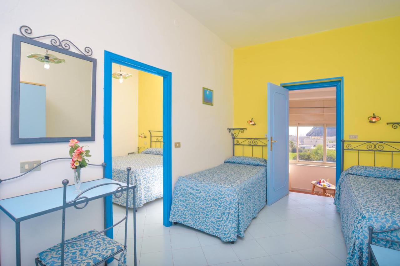 een kamer met twee bedden en een spiegel bij Hotel Celeste in Procida