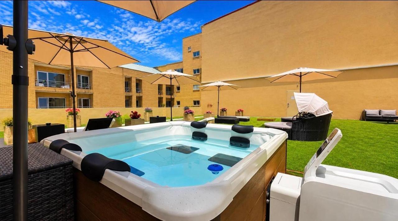 een jacuzzi op een terras met parasols bij Hotel de Ilhavo Plaza & Spa in Ílhavo