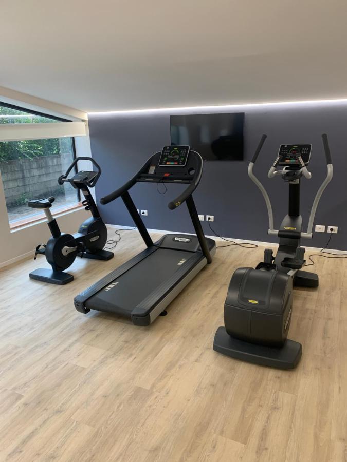 een fitnessruimte met drie hometrainers en een flatscreen-tv bij Hotel Leon d'Oro in Verona