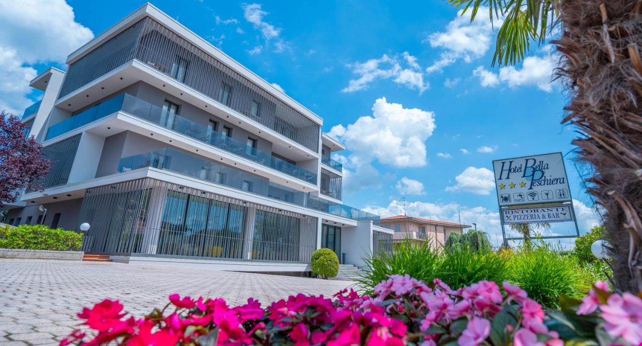 een gebouw met roze bloemen ervoor bij Hotel Bella Peschiera in Peschiera del Garda