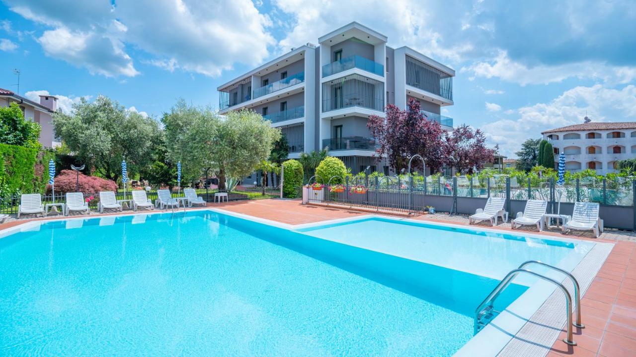 een zwembad voor een gebouw bij Hotel Bella Peschiera in Peschiera del Garda