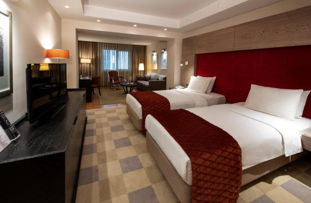een hotelkamer met twee bedden en een televisie bij Agaoğlu My City Hotel Istanbul in Istanbul