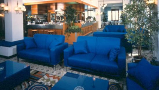 een lobby met blauwe banken en een bar bij Hotel Majestic in Pesaro