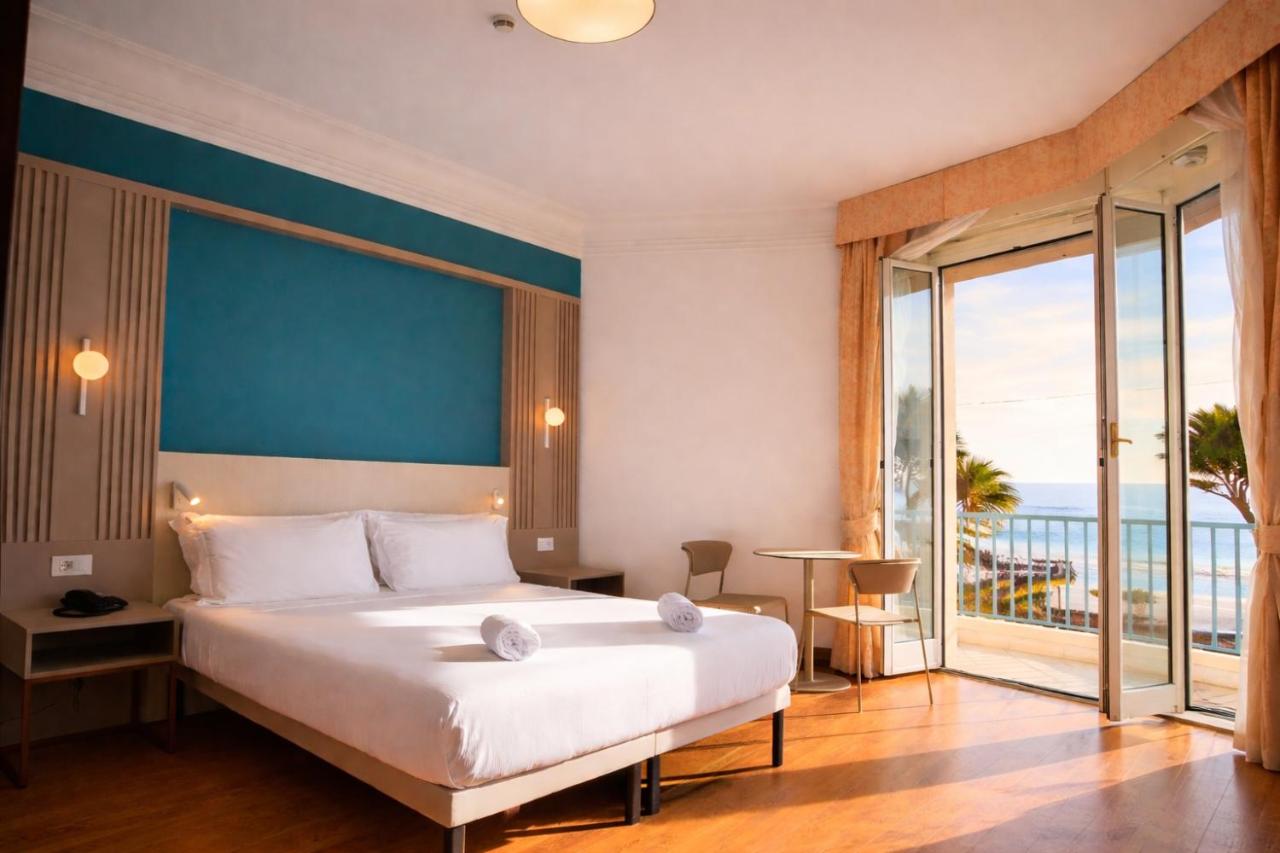 een slaapkamer met een groot bed en een groot raam bij LVG Hotel Collection - Majestic in Alassio