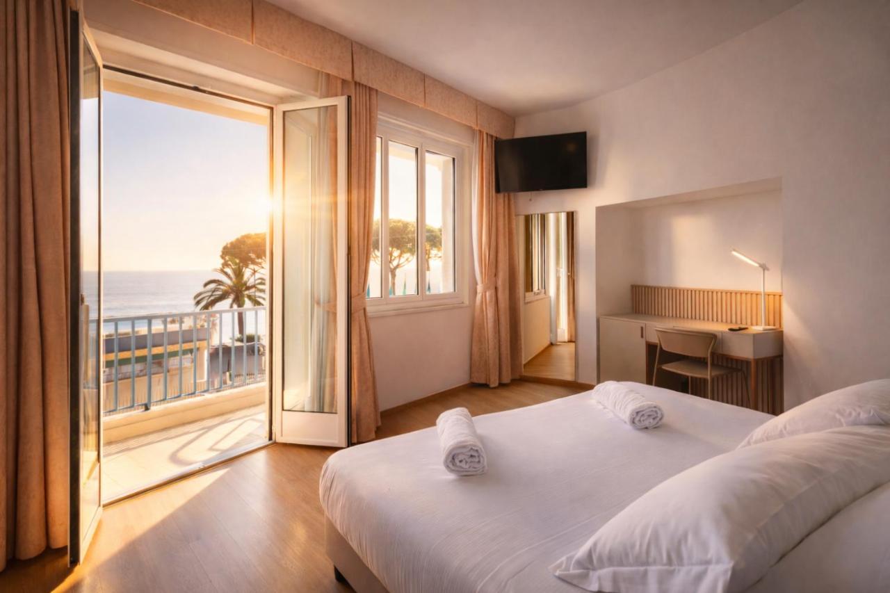 een slaapkamer met een bed en uitzicht op de oceaan bij LVG Hotel Collection - Majestic in Alassio