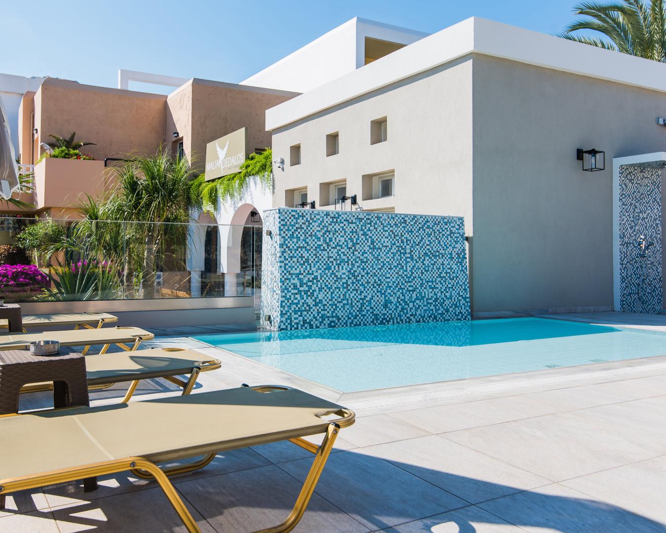 Zwembad omringd door palmbomen — Dedalos Hotel