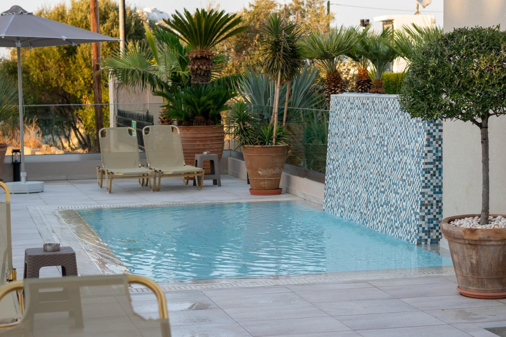Zwembad omringd door palmbomen — Dedalos Hotel