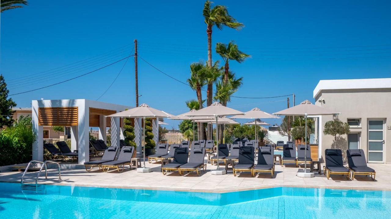 een zwembad met ligstoelen en parasols bij Dedalos Hotel in Malia +73 foto's