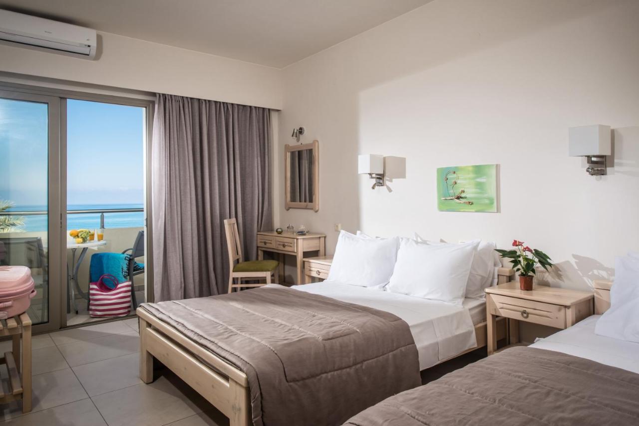 een hotelkamer met twee bedden en een balkon bij Malliotakis Beach Hotel "by Checkin" in Stalida