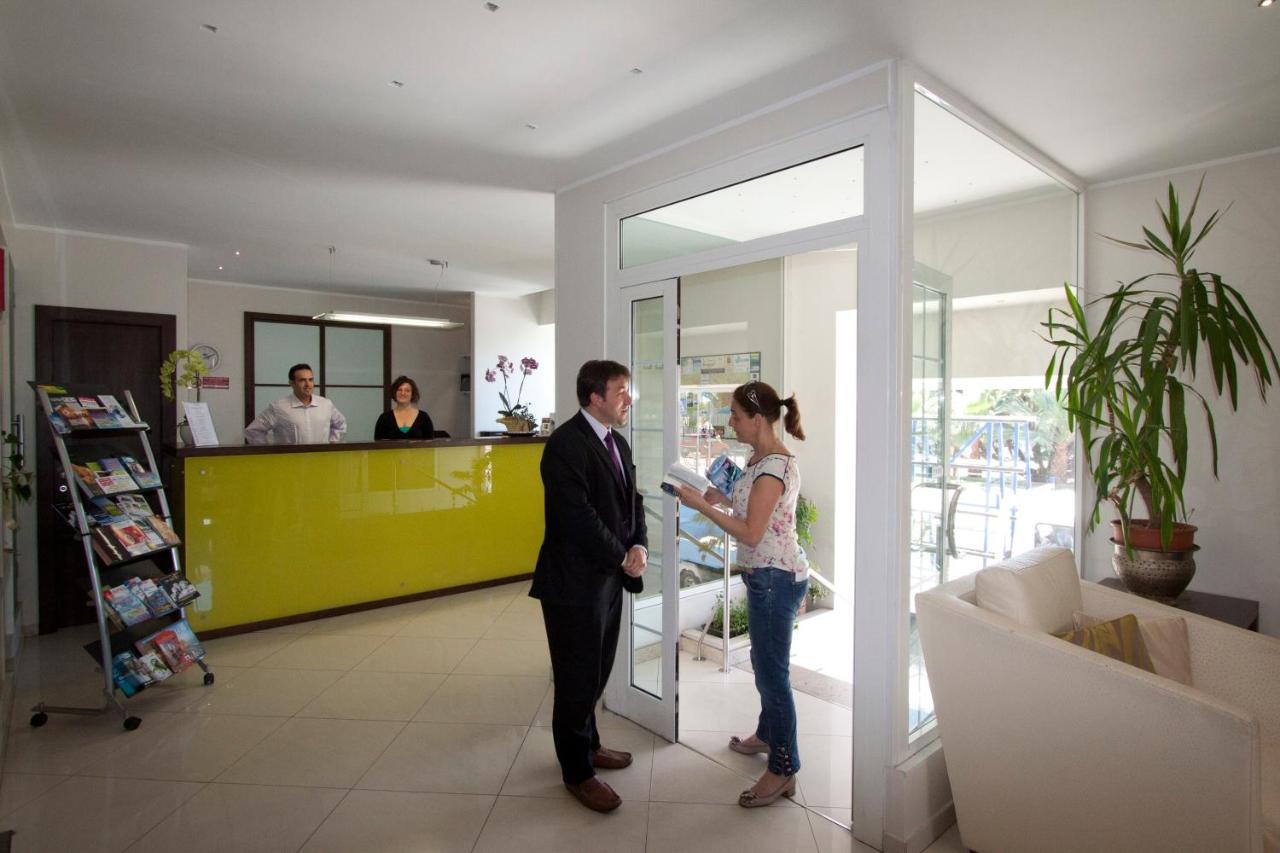 een man en een vrouw staan in een lobby bij Hotel Marinella in Sanremo