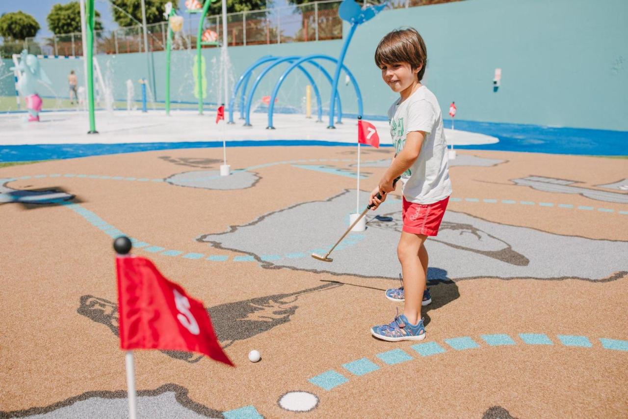 een jonge jongen die golf speelt op een speelplaats bij Maspalomas Resort by Dunas in Maspalomas
