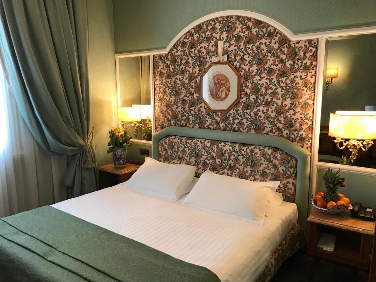 een slaapkamer met een groot bed en een bloemenmuur bij Hotel Mecenate Palace in Rome