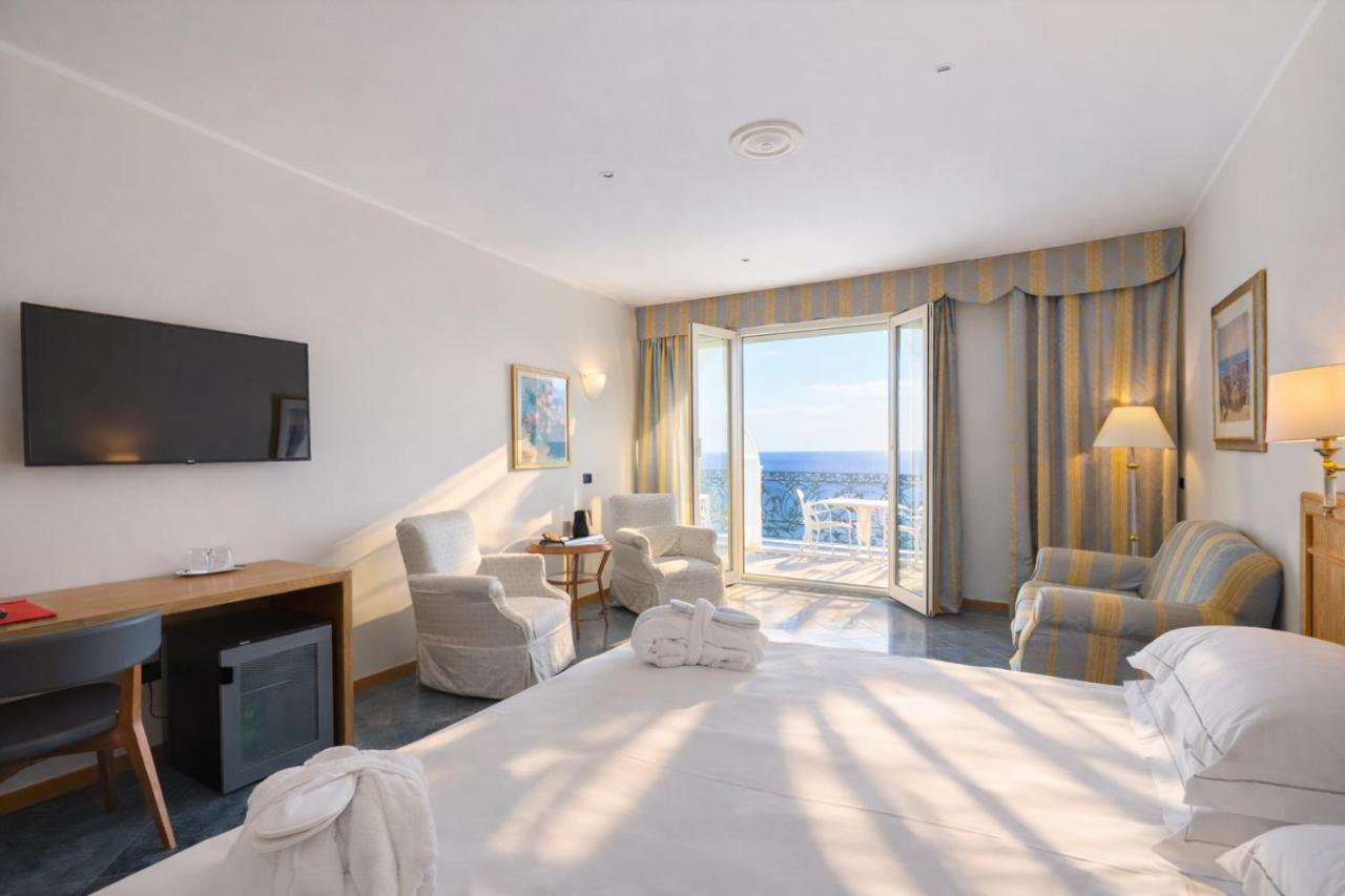 een hotelkamer met een bed, een bureau en een televisie bij LVG Hotel Collection - Grand Hotel Mediterranee in Alassio