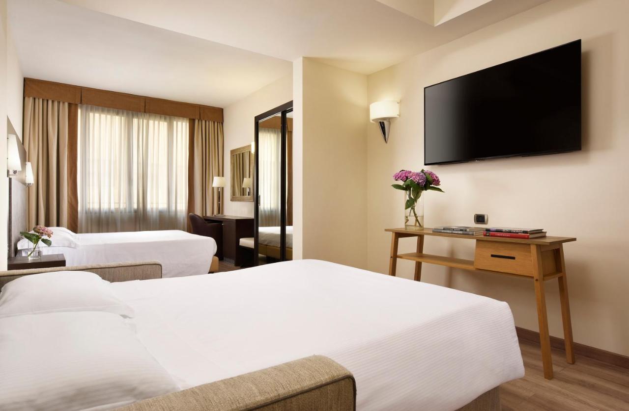 een hotelkamer met twee bedden en een flatscreen-tv bij FH55 Grand Hotel Mediterraneo in Florence