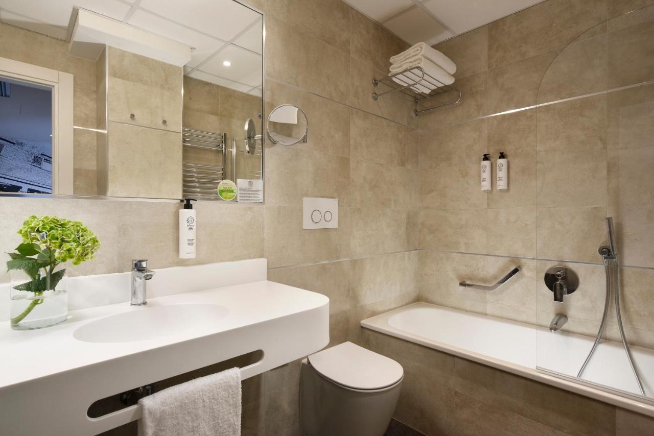 een badkamer met een wastafel, een toilet en een badkuip bij FH55 Grand Hotel Mediterraneo in Florence