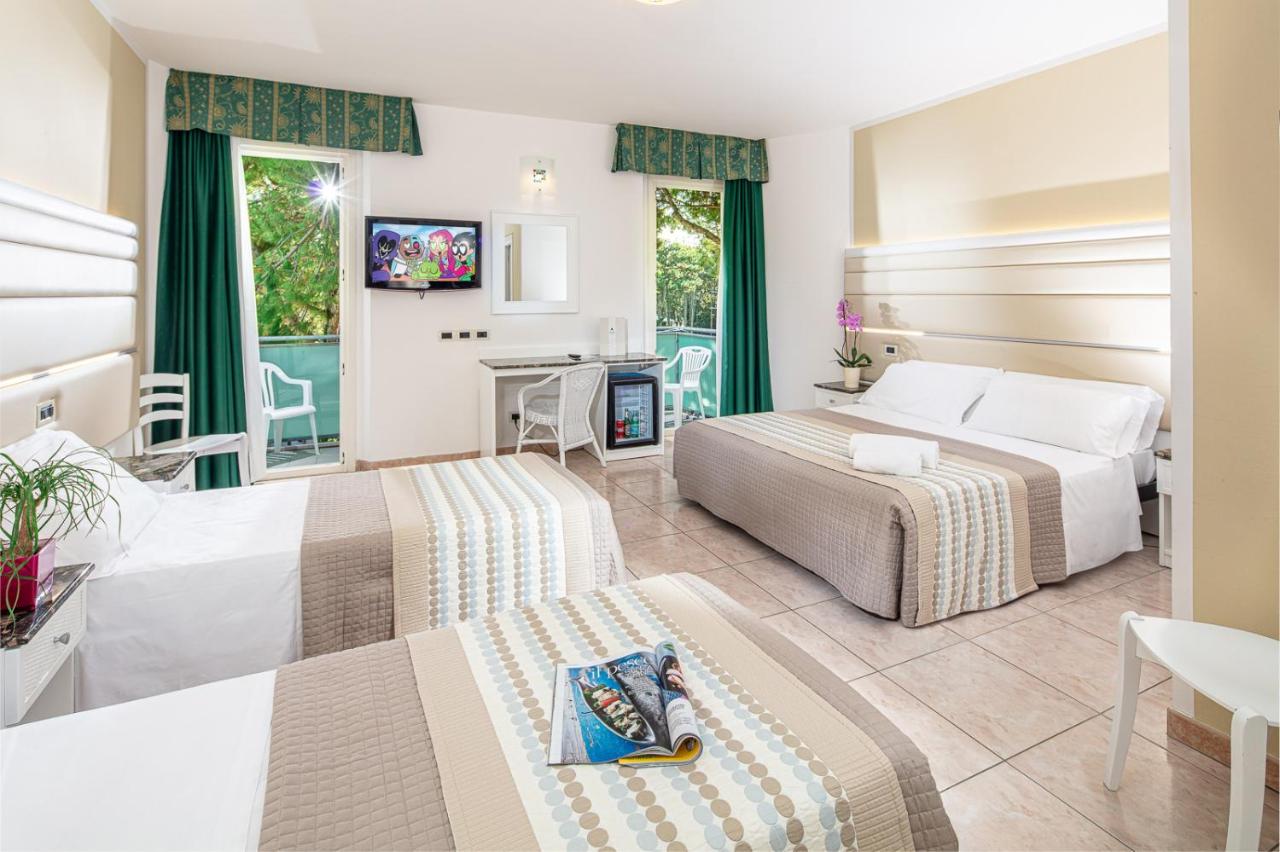 een hotelkamer met twee bedden en een tv bij Hotel Mediterraneo in Lignano Sabbiadoro