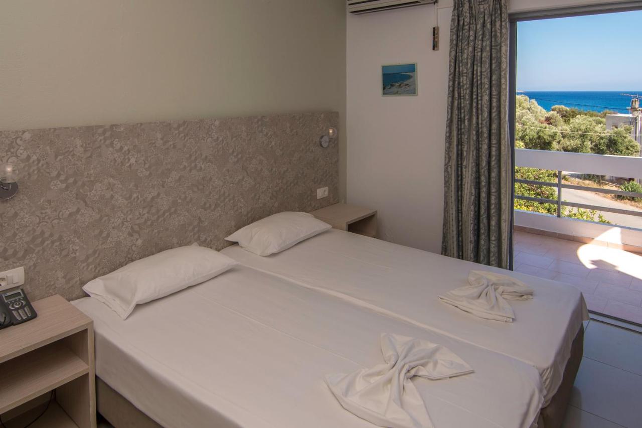 een slaapkamer met een bed en uitzicht op de oceaan bij Megim Hotel in Palaiochóra