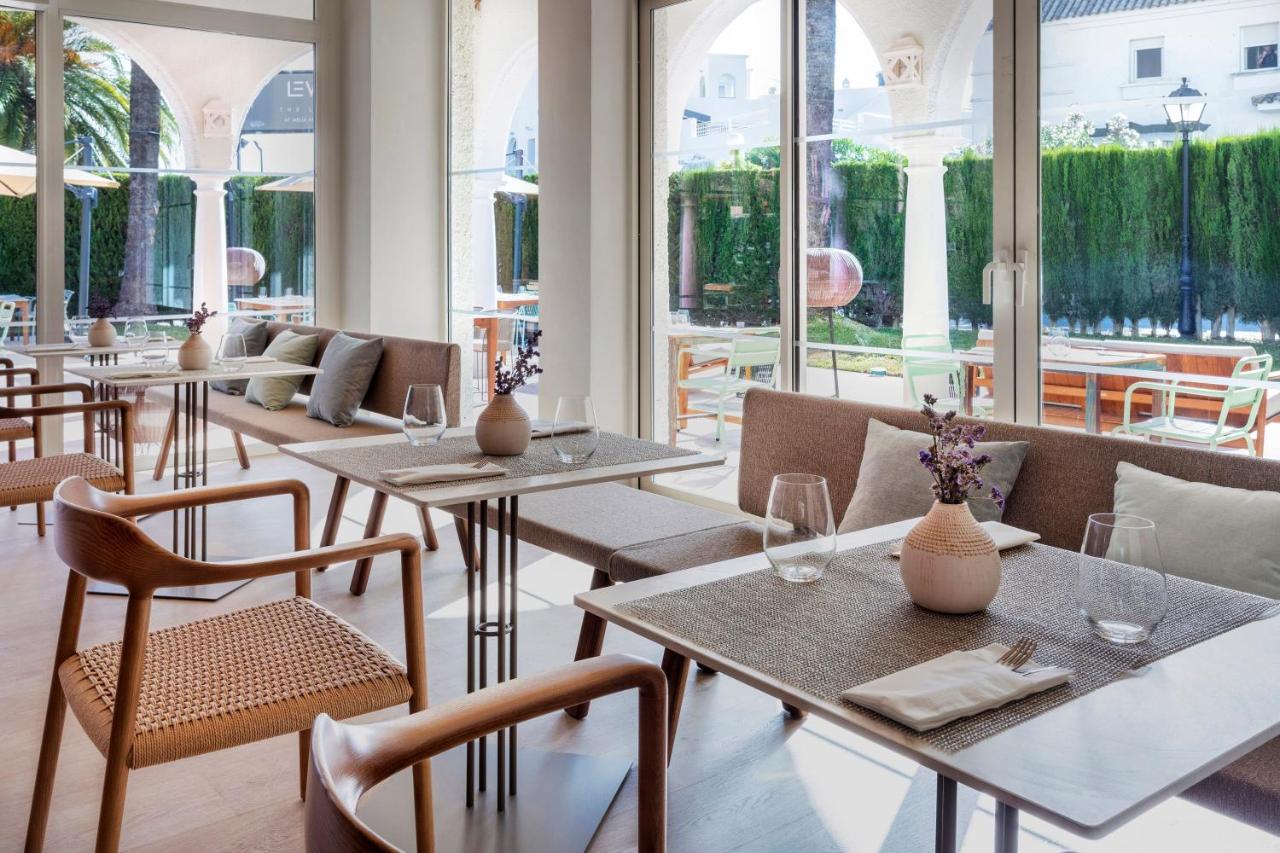 een restaurant met tafels, stoelen en ramen bij Meliá Zahara Resort & Villas in Zahara de los Atunes