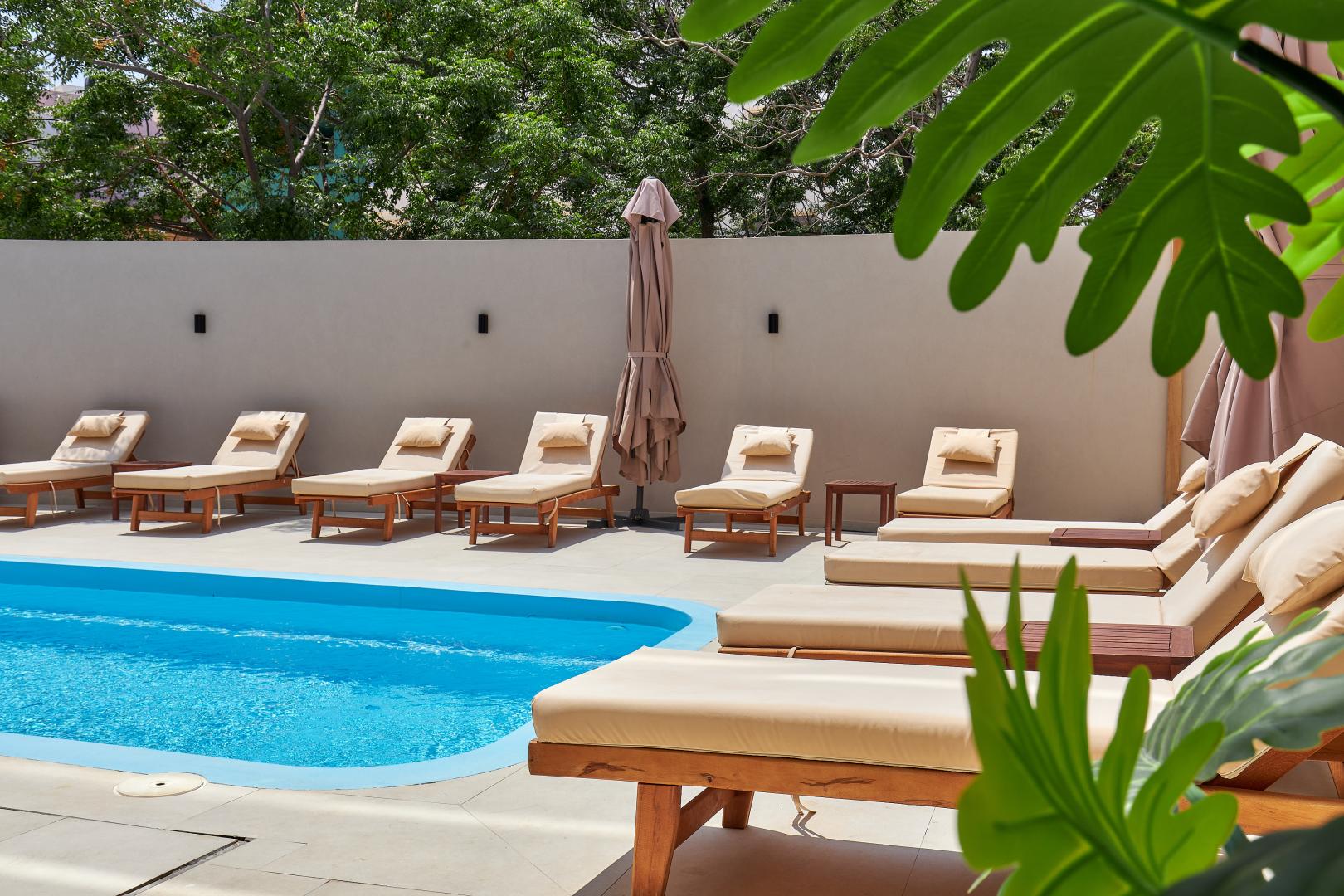 Buitenzwembad met ligbedden — Lotus Rise Hotel