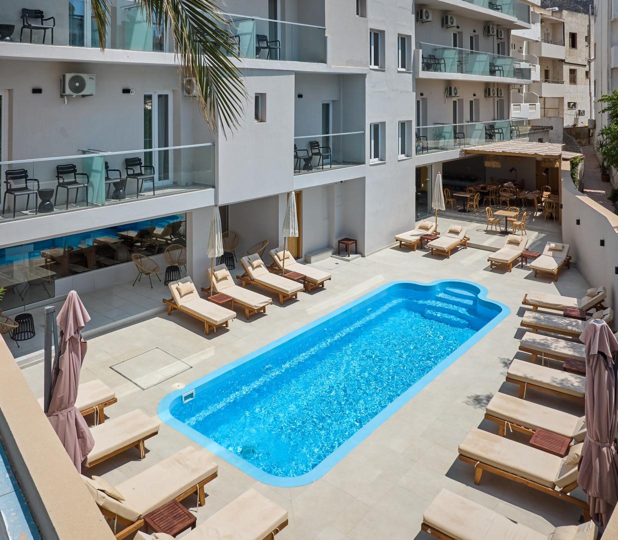 Buitenzwembad met ligbedden — Lotus Rise Hotel