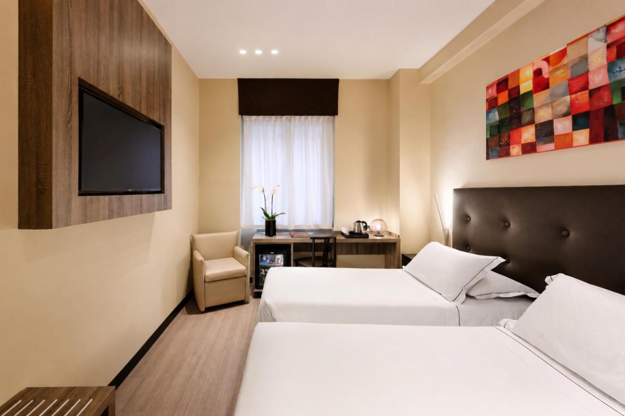 een hotelkamer met twee bedden en een televisie bij Hotel Mentana, by R Collection Hotels in Milaan