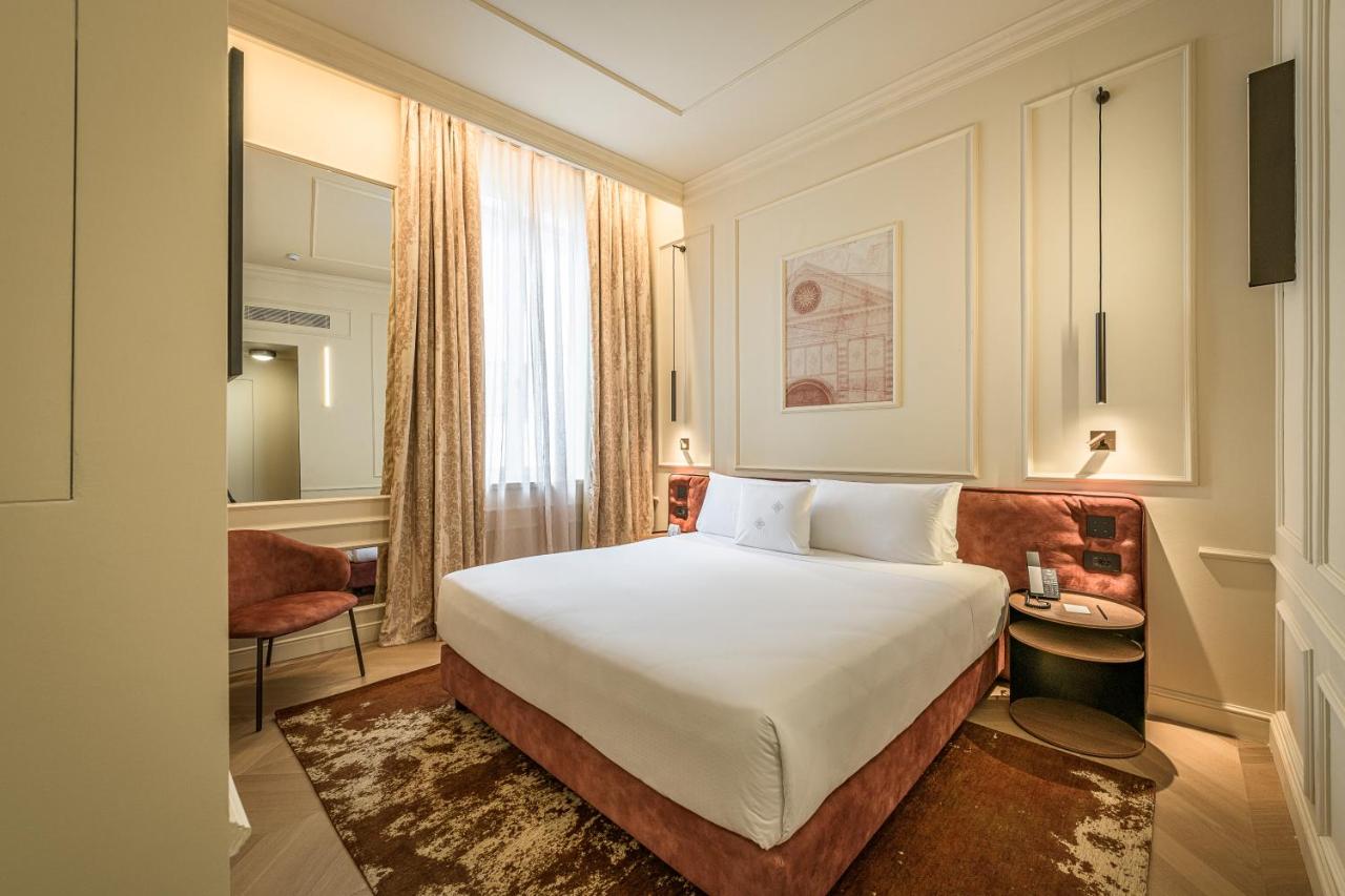 een hotelkamer met een groot bed en een bureau bij Palazzo Montebello in Florence