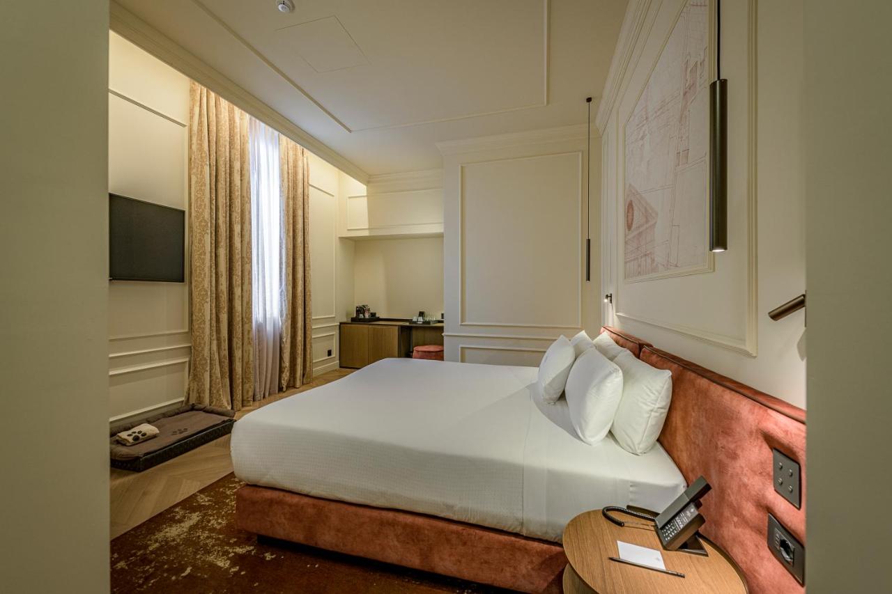 een slaapkamer met een wit bed en een tafel bij Palazzo Montebello in Florence