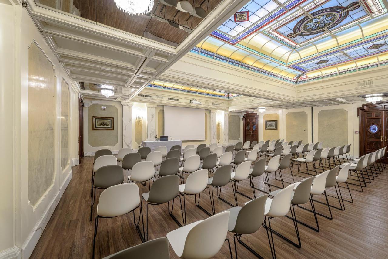 een kamer met rijen stoelen en een plafond bij Palazzo Montebello in Florence