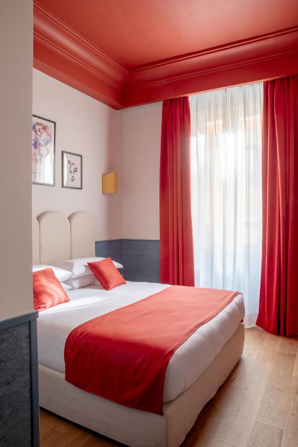 een slaapkamer met een groot bed met rode gordijnen bij Hotel Montecarlo in Rome