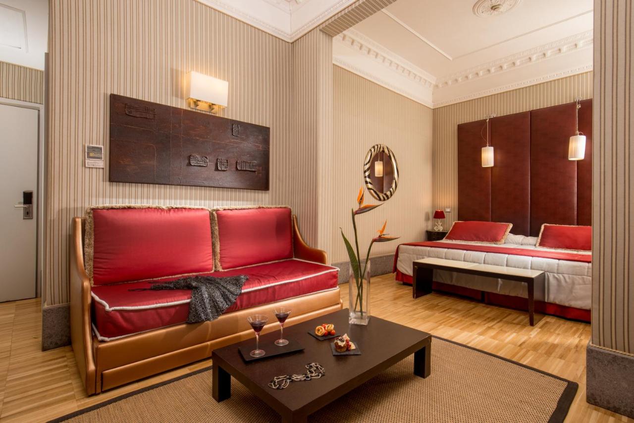 een woonkamer met een bank en een bed bij Hotel Morgana in Rome