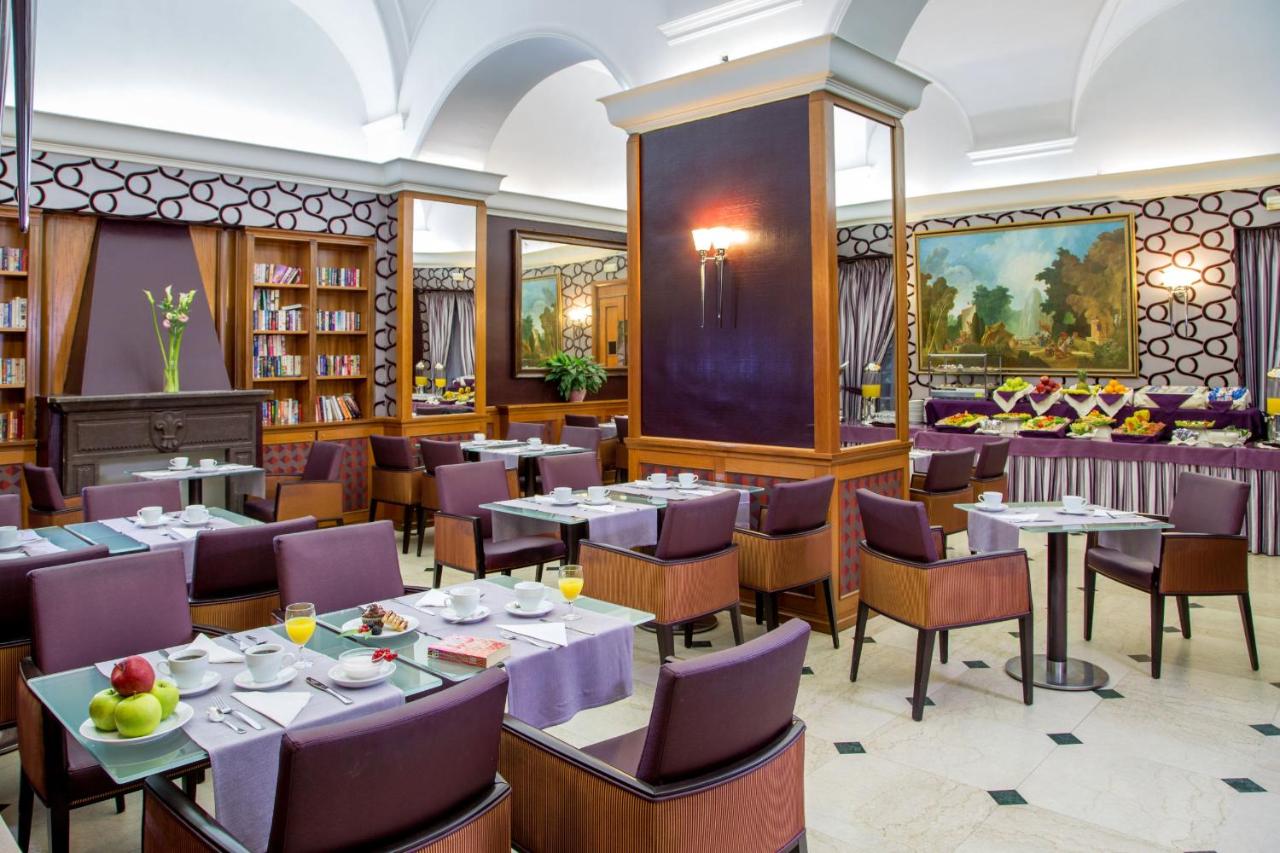 een restaurant met tafels en stoelen in een bibliotheek bij Hotel Morgana in Rome