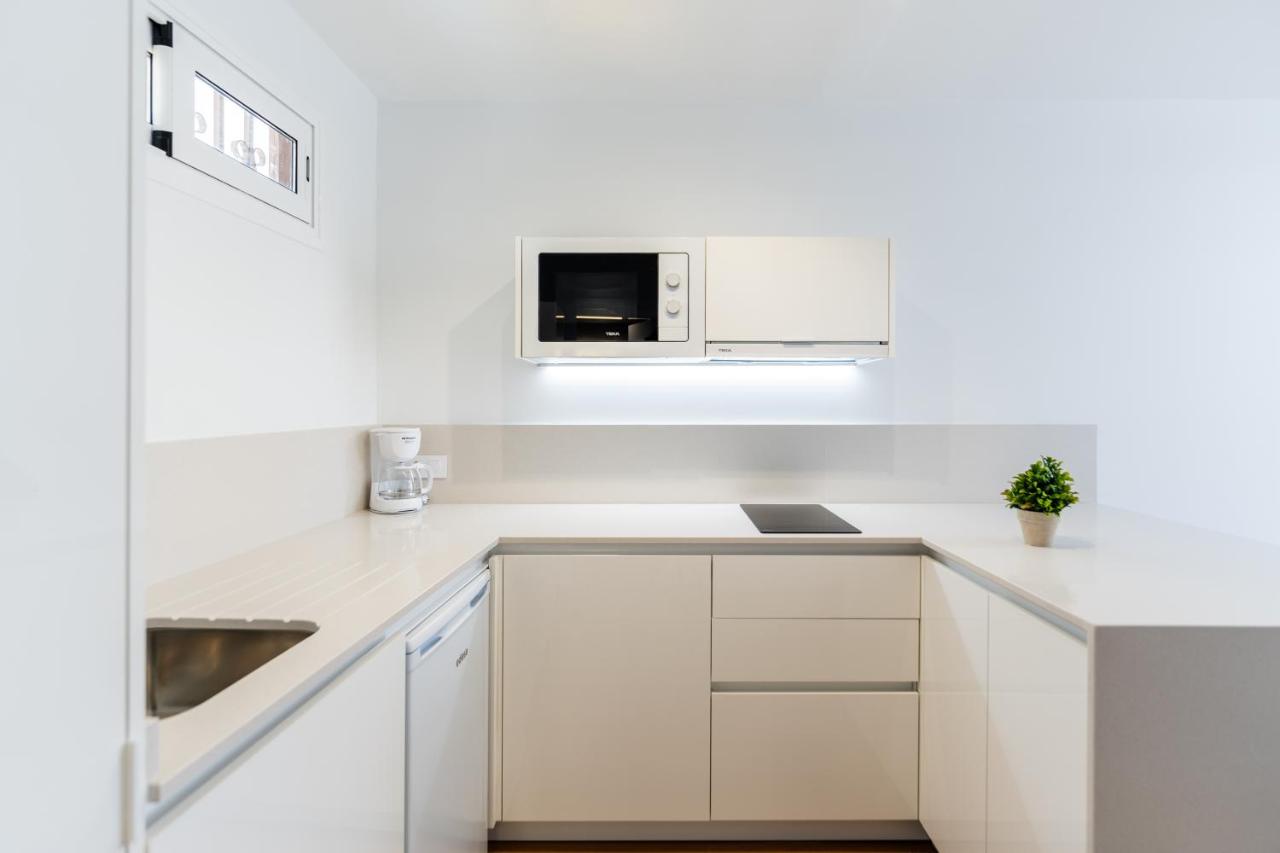 een witte keuken met een spoelbak en een magnetron bij Alsol Nara in Playa del Inglés