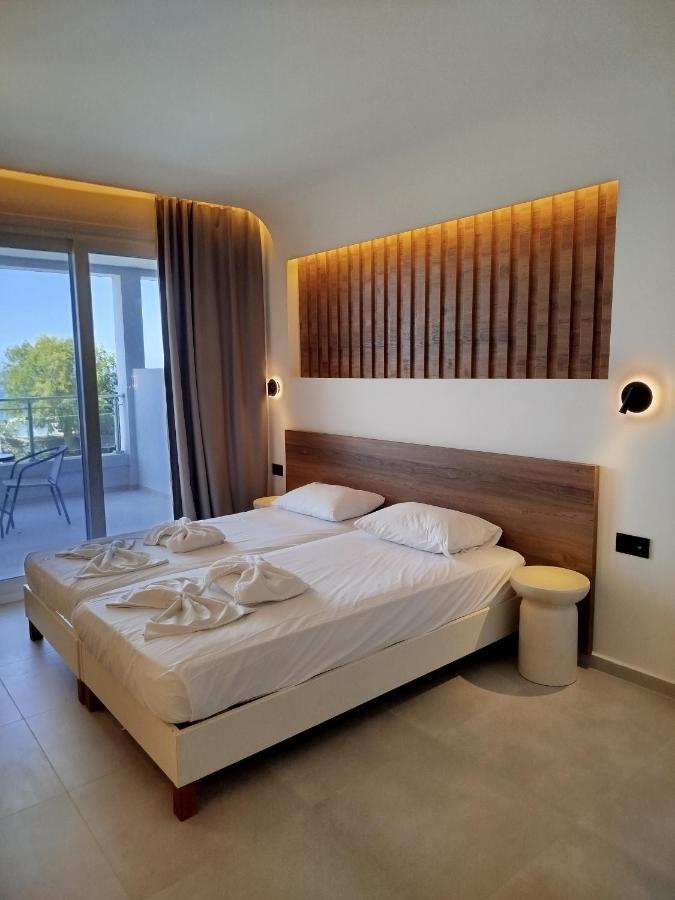 een slaapkamer met een groot bed en een balkon bij Neon Hotel in Stalida