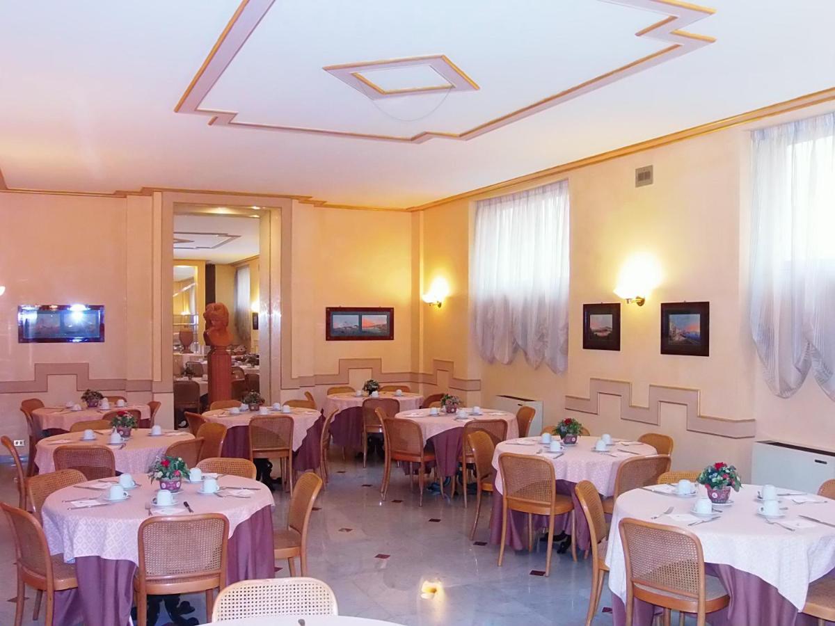 een restaurant met tafels en stoelen met witte tafelkleden bij Hotel Nuovo Rebecchino in Napels