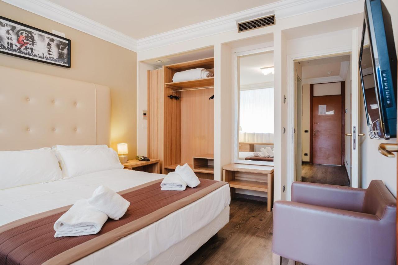 een hotelkamer met een bed en een stoel bij Nyala Suite Hotel in Sanremo +23 foto's