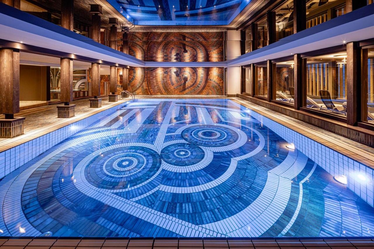 een zwembad met een spiraalvormig ontwerp in het midden bij Sporthotel Obereggen in Obereggen