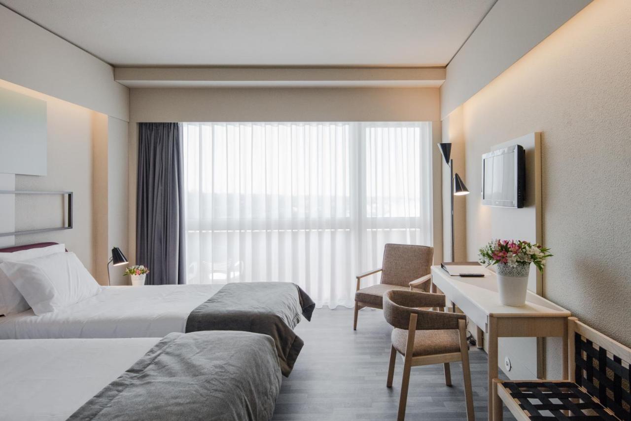 een hotelkamer met twee bedden en een bureau bij Axis Ofir Beach Resort Hotel in Esposende