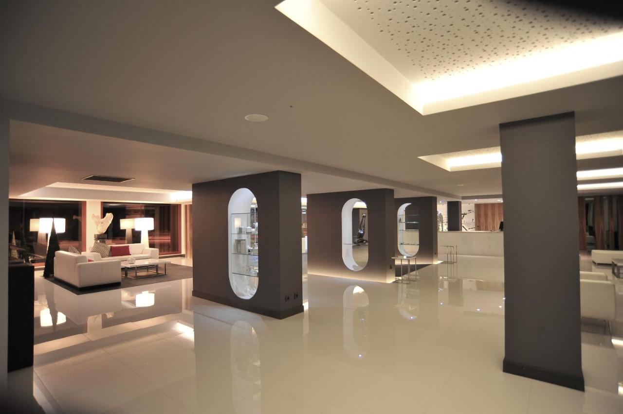 een lobby met twee spiegels en een bank in een kamer bij Axis Ofir Beach Resort Hotel in Esposende