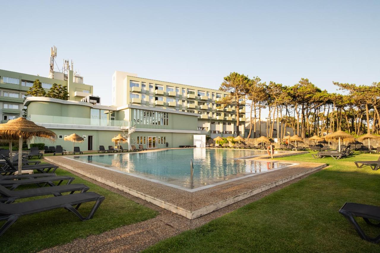 een hotel met een zwembad met ligstoelen en parasols bij Axis Ofir Beach Resort Hotel in Esposende