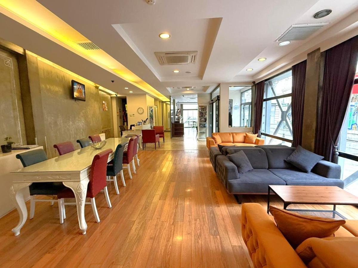 een woonkamer met een bank, een tafel en stoelen bij Hotellino Istanbul in Istanbul