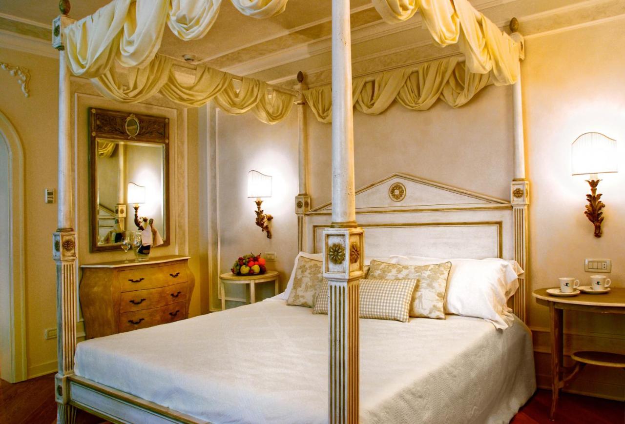 een slaapkamer met een hemelbed met baldakijn bij Garda Hotel San Vigilio Golf in Pozzolengo