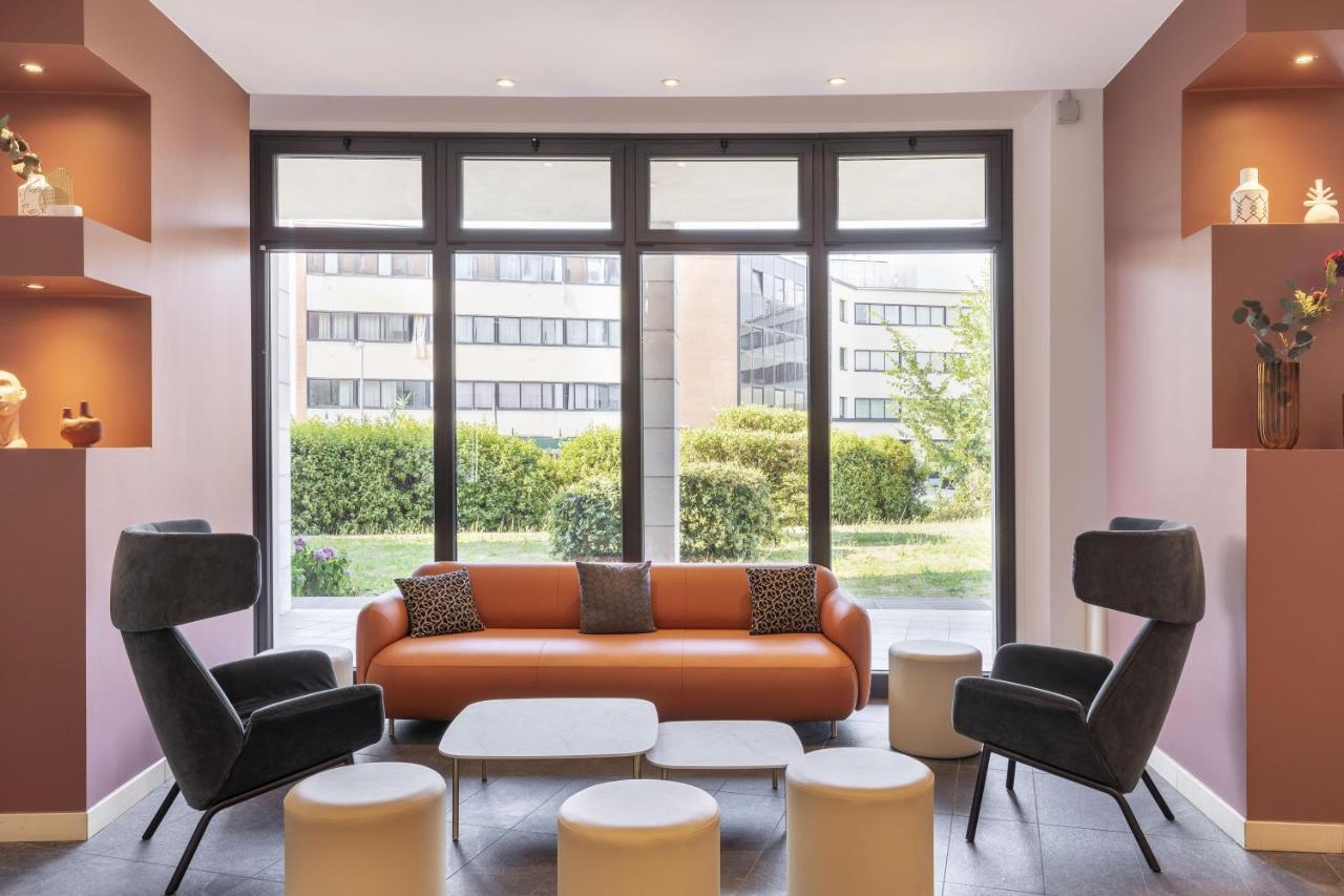 een woonkamer met een bank en stoelen en een groot raam bij B&B Hotel Sassuolo in Sassuolo