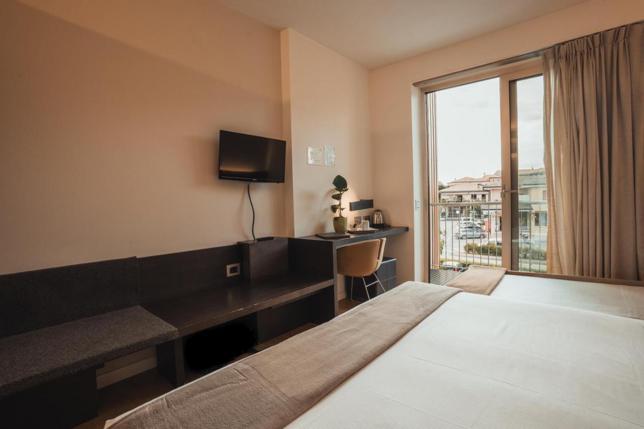 een hotelkamer met een bed, een bureau en een raam bij Mod 05 Bike Hotel in Castelnuovo del Garda