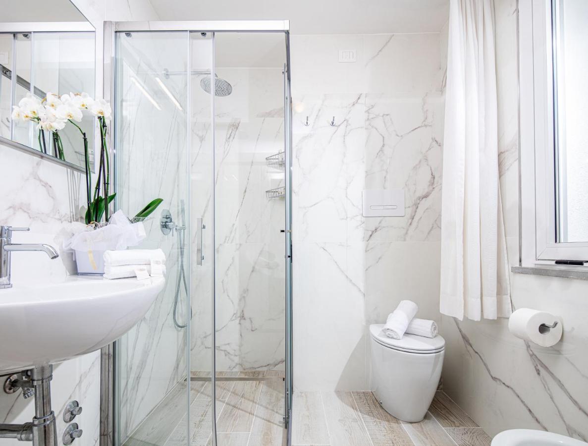 een badkamer met een douche, een wastafel en een toilet. bij Hotel Palace in Lignano Sabbiadoro