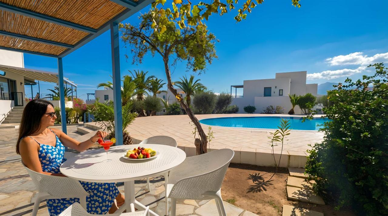 een vrouw zit aan een tafel met een fruitschaal bij Palatia Village Hotel Apartments in Chersonissos