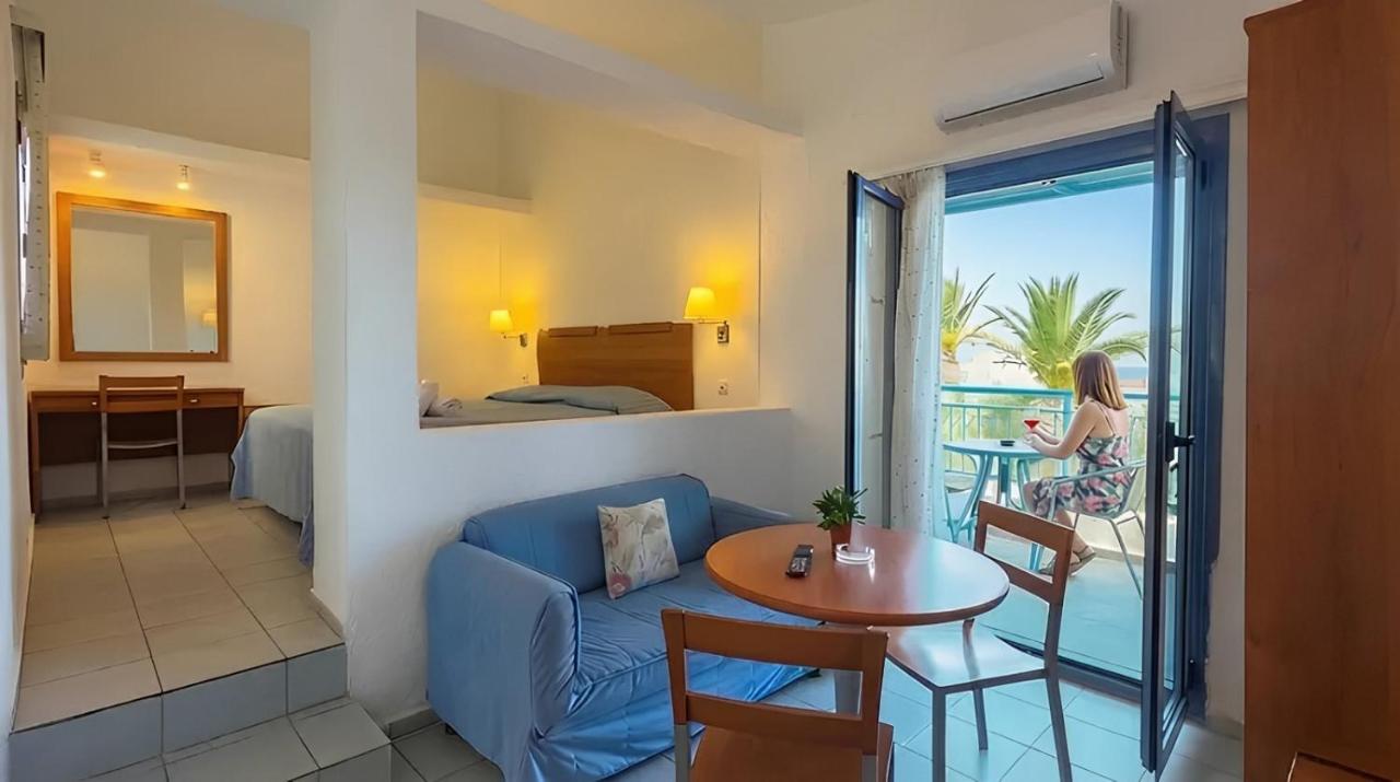 een woonkamer met een bank en een tafel en een kamer met een balkon bij Palatia Village Hotel Apartments in Chersonissos